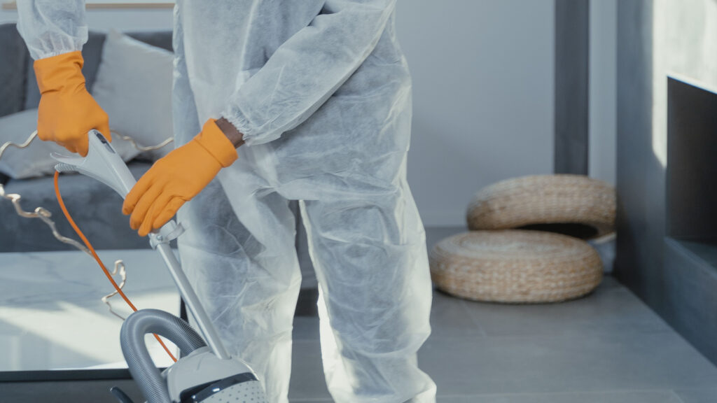 Person reinigt Industriefläche in Reinigungsanzug